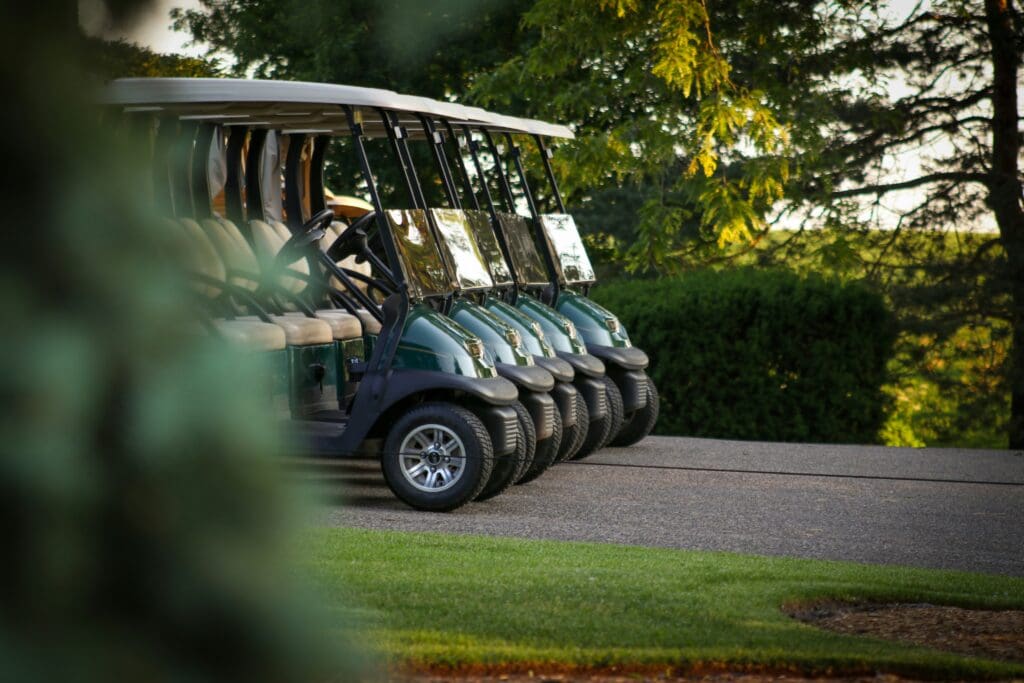 Row of green golf carts viewed in side profile